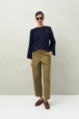 Pantalón negro de algodón con calce recto y relajado, tiro medio/alto, bolsillos de parche en la parte delantera y puños anchos.