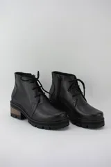 Borcego negro de cuero con plataforma tractorada, cordones y cierre lateral.