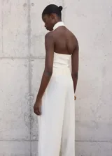 Top de punto fino color blanco, sin mangas, con cuello halter y diseño entallado.