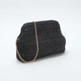 Bolso tipo clutch de estructura rígida, tejido en rafia color negro, con cierre superior y cadena metálica dorada para llevar al hombro.