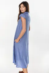 Vestido midi color azul de lino italiano, con diseño camisero, cuello camisero, mangas cortas abullonadas, cierre frontal con botones y bolsillos laterales.