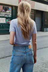 Chaqueta de punto celeste, de manga corta, con cuello solapa y cierre frontal con botones.