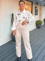 Pantalón de tiro alto en color beige, de corte recto y diseño estructurado con ruedo doblado.