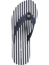 Ojotas de cuña con plataforma, plantilla con rayas horizontales azul marino y blancas, y tiras de tejido trenzado azul marino con logo de Tommy Hilfiger en dorado.