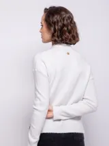 Sweater de punto tramado color rosa, de cuello alto y manga larga.