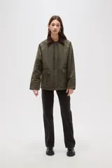 Campera de algodón estilo field jacket en color verde oliva, con cuello de pana en contraste color marrón, cierre frontal oculto y bolsillos delanteros amplios.