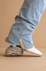 Bota de caña media en color blanco, con punta fina y taco bajo. Presenta un diseño minimalista y elegante, ideal para combinar con diversas prendas.