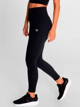 Calza deportiva de tiro alto y largo al tobillo, confeccionada en tejido técnico elástico de color negro. Presenta un diseño liso sin bolsillos, ideal para actividades físicas.
