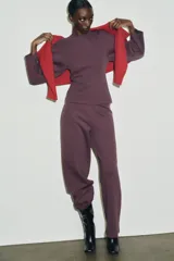 Jersey de cuello redondo y manga larga, confeccionado en tejido de punto elástico con trama compacta. Presenta un diseño con pinzas en la cintura que le otorgan una silueta entallada.