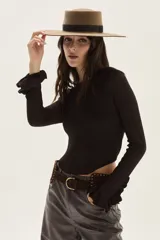Top de tejido de punto con acabado brillante, de manga larga con puños acampanados y detalle de volados. Presenta cuello redondo y diseño ajustado al cuerpo.