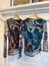 Remera de microtul con estampado abstracto en tonos azules, marrones y beige, de manga larga y cuello redondo.