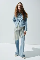 Campera corta en denim de algodón con cuello, cierre de botones y canesú en la espalda. Modelo ajustado con bolsillos parche adelante y puños abotonados.