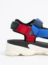 Sandalias con plataforma blanca y tiras de velcro ajustables en colores rojo, azul y amarillo.
