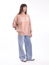 Buzo de cuello redondo y manga larga, color marrón, con estampado gráfico frontal en color lila que incluye texto y personajes animados.