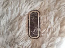 Broche para pelo artesanal de cuero con bordados en tiento fino.