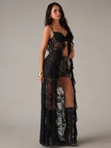 Top de encaje negro con diseño de bralette y una capa larga transparente con volados en el frente.