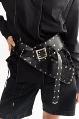 Cinto faja de cuero con estampado de vaca en blanco y negro, con hebilla metálica rectangular.