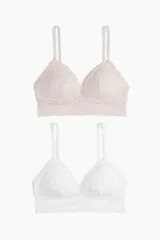 Pack de dos soutiens tipo bralette de encaje con copas acolchadas y relleno extraíble. Presentan breteles ajustables y diseño sin aros ni cierres.