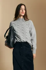Sweater de punto color beige con diseño geométrico en relieve, cuello alto y mangas largas con puños acanalados.