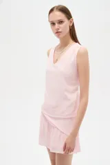 Musculosa de viscosa color rosado, con diseño broderie, breteles anchos, cuello en V y corte holgado.