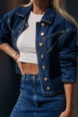 Campera de jean azul con corte vintage y pespuntes en hilo color maíz. Detalles de jean negro en puños, cintura y costados.