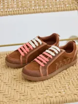 Championes marrones de cuero con cordones intercambiables blancos y rosas, y logo bordado en el lateral.