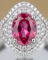 Anillo de plata con piedra central tallada en corte ovalado de color fucsia, rodeada por un doble pavé de circones brillantes.