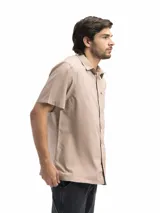 Camisa negra de manga corta con cuello clásico, cierre frontal con botones y bolsillo de parche en el pecho.