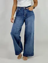 Pantalón de jean azul de tiro alto, corte wide leg y ruedo desflecado.