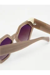 Lentes de sol hexagonales color marrón con marco bicolor beige y lentes degradadas.