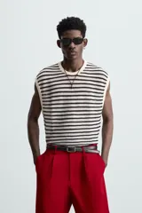 Camiseta sin mangas de punto con cuello redondo, tejido abierto a rayas horizontales negras y blancas, con ribetes en color crema.