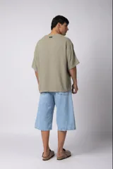 Remera de corte oversize confeccionada en tejido texturado tipo lino, de color beige, con cuello redondo amplio y mangas cortas de calce relajado.