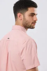 Camisa de manga corta de algodón en color celeste con microdiseño geométrico a cuadros, cuello camisero y bolsillo frontal con logo bordado.