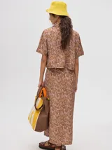 Falda midi tipo pareo color verde con estampado estilo tie-dye en tonos azul, naranja y blanco, con tiras ajustables en la cintura.