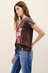 Remera de algodón marrón oscuro con estampa frontal que presenta un leopardo y la inscripción en tono fucsia.