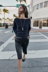 Jersey de punto color mostaza con cuello barco, manga larga con sisa ancha y detalle de cinturón fino integrado en la cintura.