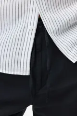 Short negro de corte regular fit, confeccionado en mezcla liviana de lino y algodón. Posee cintura elástica con cordón de ajuste, bragueta con botón, bolsillos en las costuras laterales y un bolsillo ojal en la parte posterior.