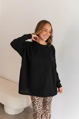 Conjunto de dos piezas compuesto por un buzo de cuello redondo y mangas largas con diseño holgado y un pantalón de corte recto y tiro alto. Ambas prendas están confeccionadas en tejido de punto acanalado.