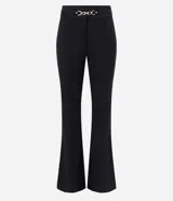 Pantalón de corte flare confeccionado en tejido punto roma, con ajuste ceñido en caderas y muslos, y apertura acampanada desde la rodilla. Presenta detalle decorativo metálico en la cintura y cierre frontal.