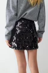 Minifalda ajustada completamente cubierta de lentejuelas negras brillantes. Confeccionada en tejido de punto elástico para mayor comodidad.