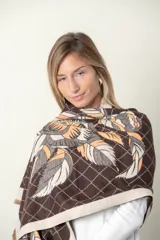 Pashmina rectangular color marrón con estampado de hojas en tonos beige y naranja, y diseño de rombos.