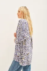 Saco tipo cardigan abierto de tejido liviano con estampado animal print en tonos azul y blanco. Presenta detalles bordados con lentejuelas a lo largo del diseño.