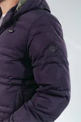 Campera puffer acolchada de color azul marino, con capucha ajustable, cierre frontal y bolsillos laterales. Diseño de corte recto y acabado mate.