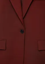 Chaqueta de traje color bordó con solapas de muesca, cierre frontal de un botón, bolsillos con solapa y forro interior.