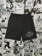 Short deportivo negro con cintura elástica ajustable con cordón, bolsillos laterales y estampado blanco con la leyenda "Team Black 03'" en la pierna derecha.