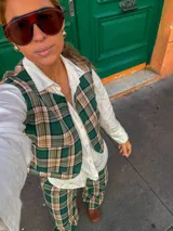 Chaleco de corte sastrero con estampado de cuadros en tonos verde, beige y negro, con cierre frontal de botones.
