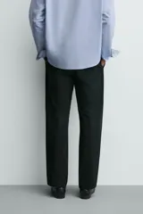 Pantalón de corte regular fit confeccionado en tejido mezcla de algodón. Presenta cintura con detalle de pliegues en el delantero, bolsillos frontales y bolsillos traseros de vivo con botón. Cierre frontal con cremallera y botón.
