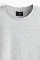 Remera de algodón liviano color gris melange, de cuello redondo y mangas cortas, con corte estándar.