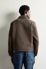 Cazadora regular fit de paño en color marrón, con cuello solapa, manga larga con puño abotonado, bolsillos de vivo en la cadera y cierre frontal con cremallera.