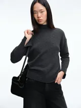 Sweater de cuello alto confeccionado en tejido de lana y cachemira, de corte holgado con mangas largas y terminaciones acanaladas en puños y ruedo.